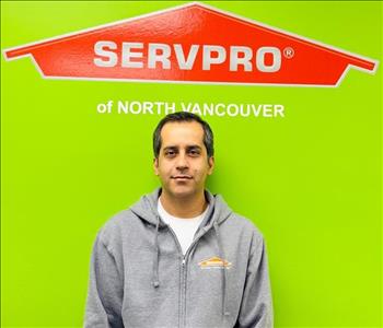 SERVPRO employee in front of green background.